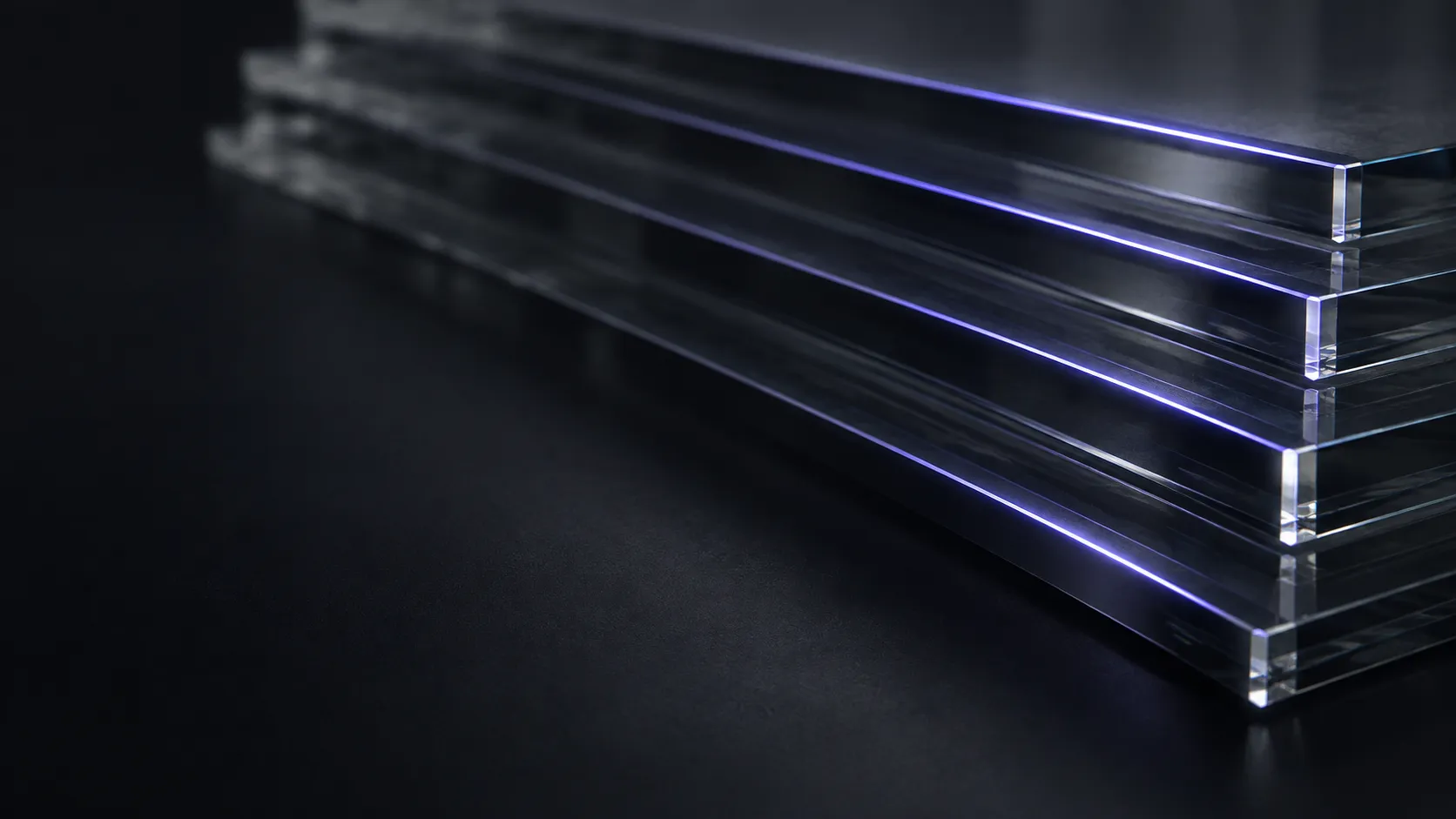 Edges of stacked glass panels catching a line of light